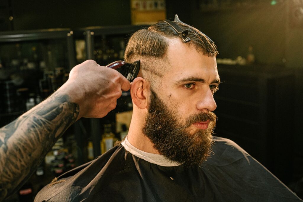 Barber using clippers to cut a customer's hair