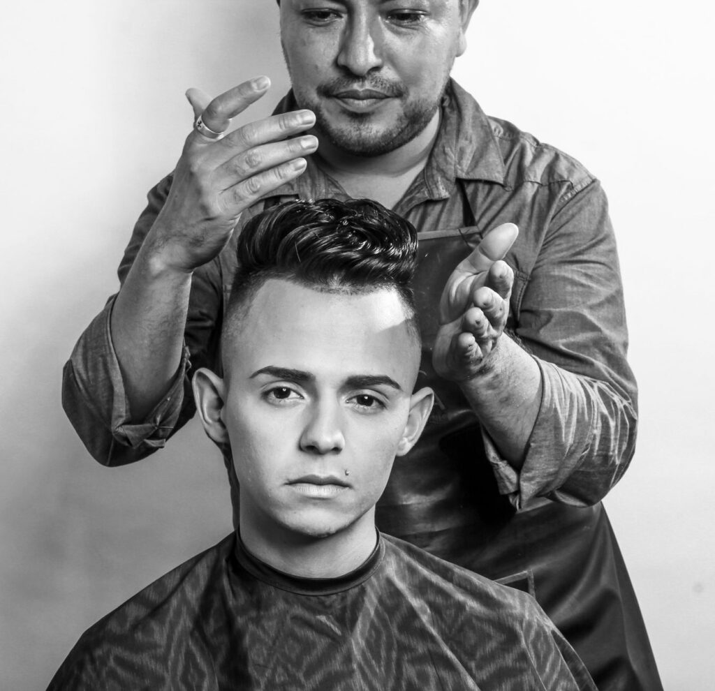 Barber applying styling product to customer's hair