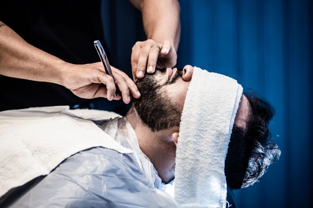 Barber preparing hot towels for a traditional shave service