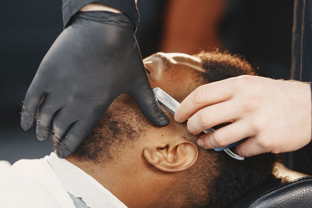 Barber preparing to give a hot towel shave with straight razor
