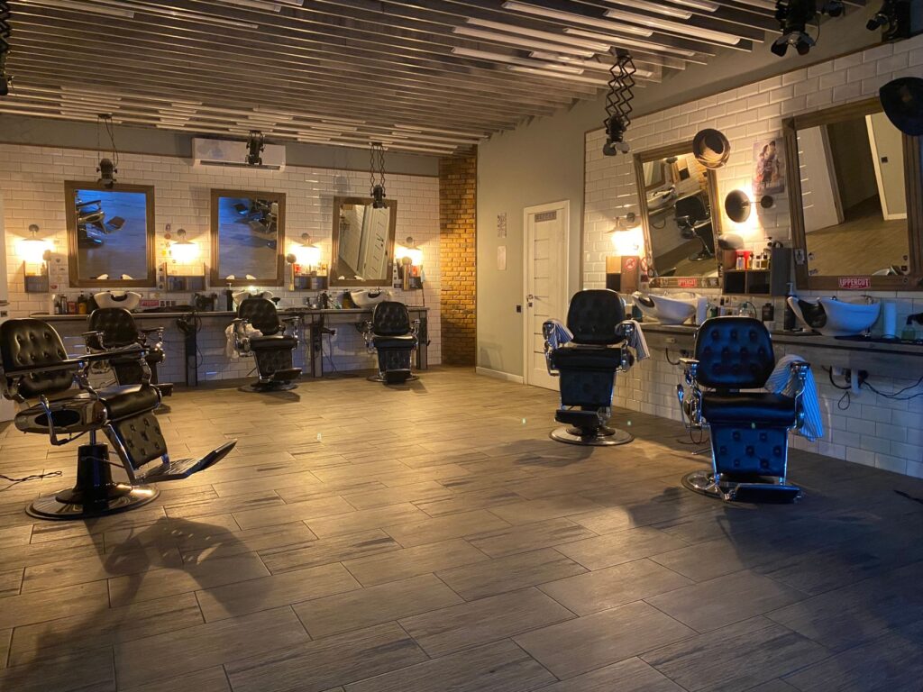 Traditional barber shop interior with leather chairs and mirrors along the wall